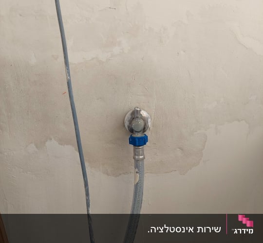 צינור מים מחובר לברז על קיר
